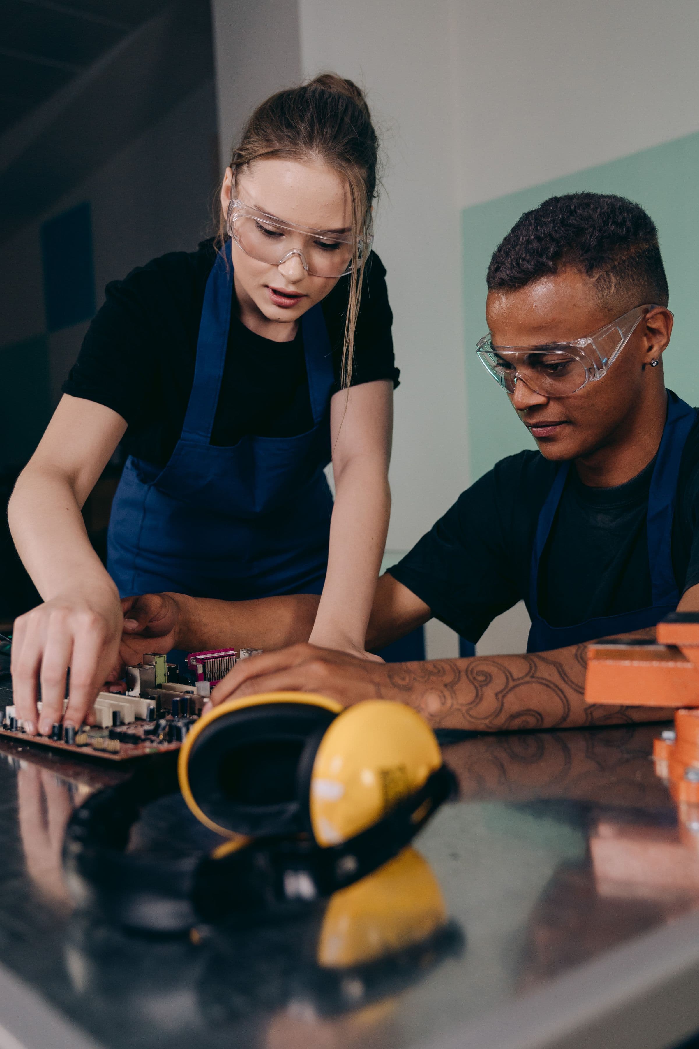 Two electronics engineers testing components in a modern workshop