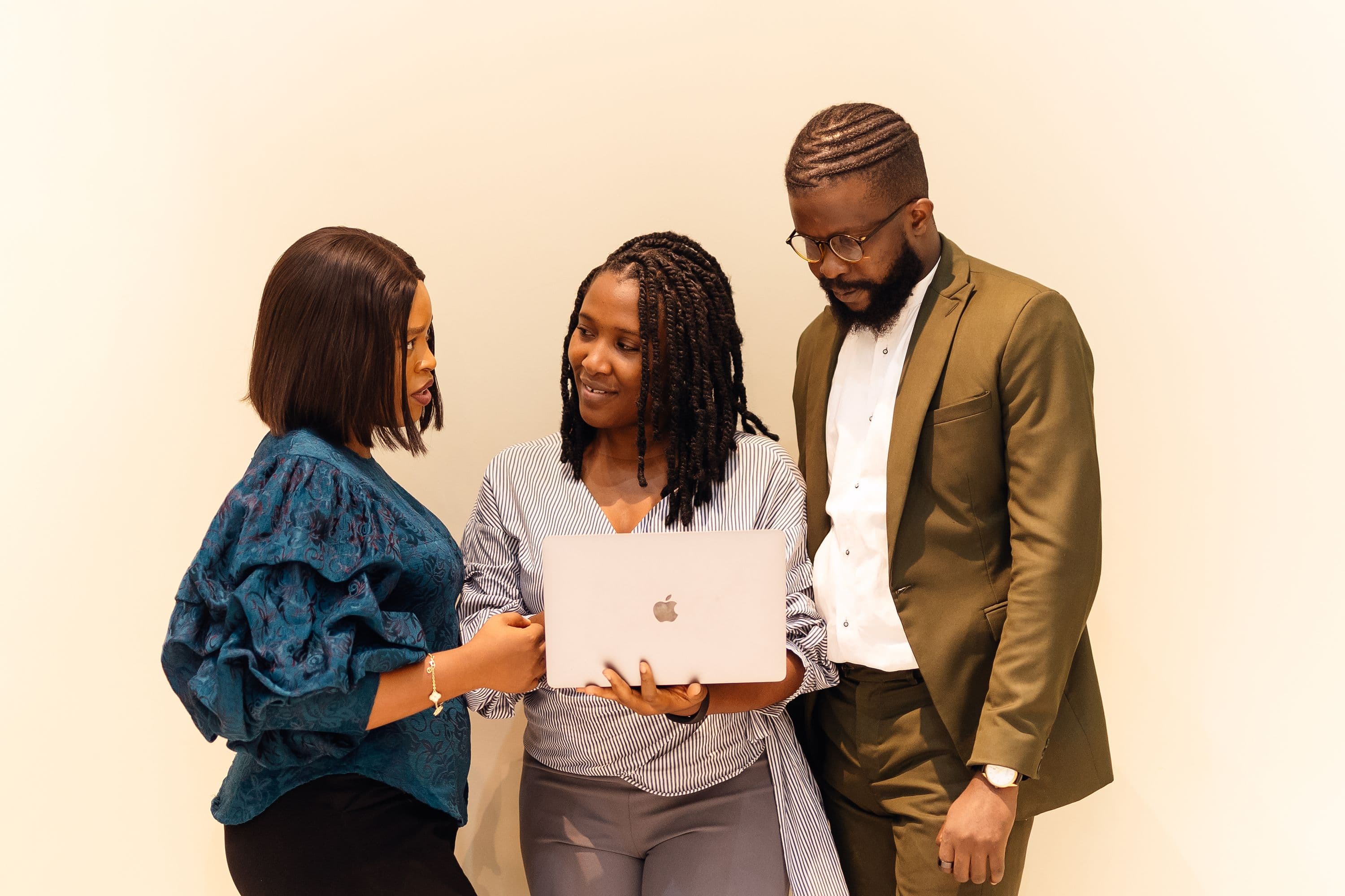 Three young professionals reviewing an editorial project on a laptop